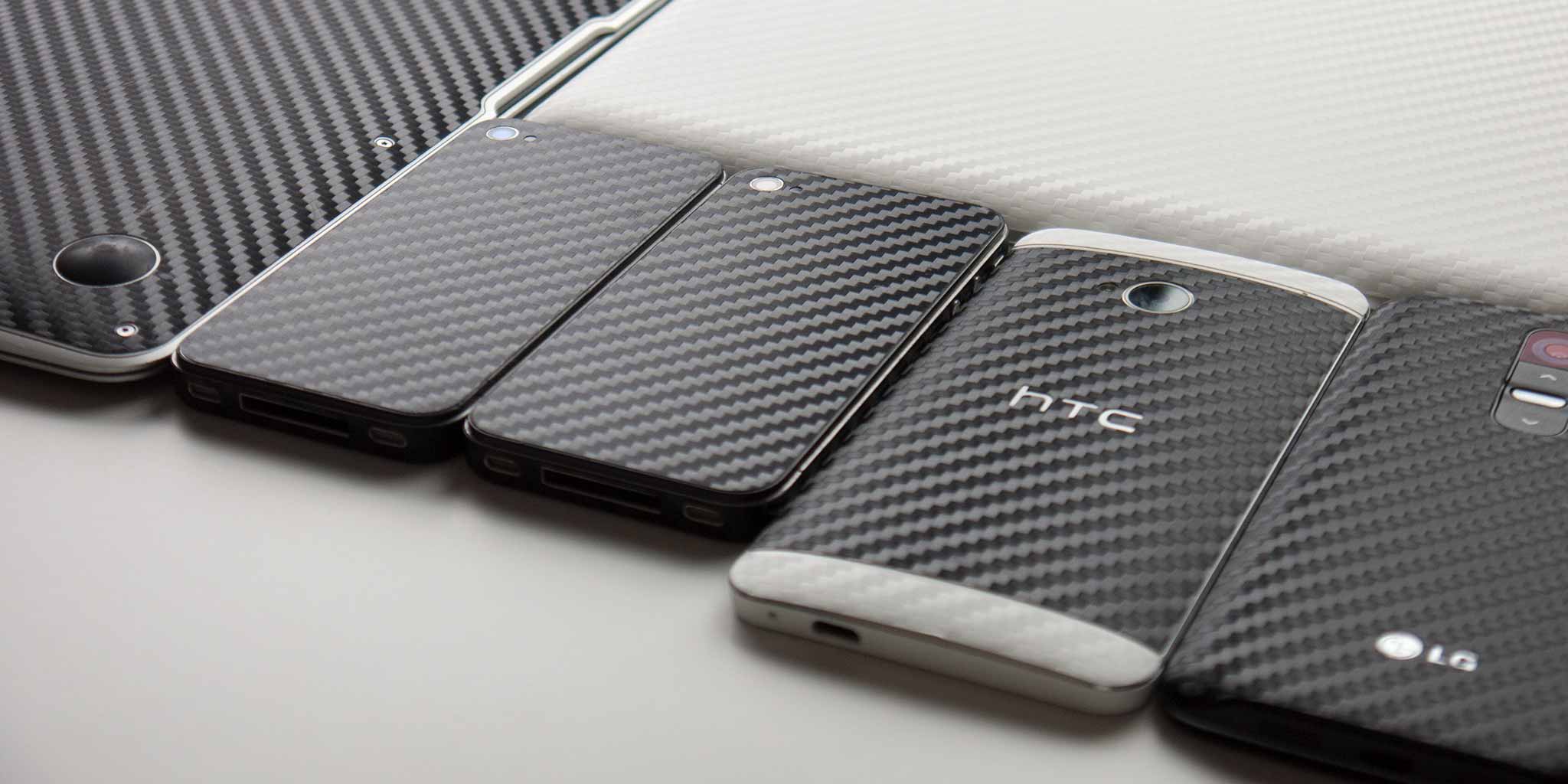 A lineup of phones and tablets, each wrapped in a carbon-fibre UKarbon skin