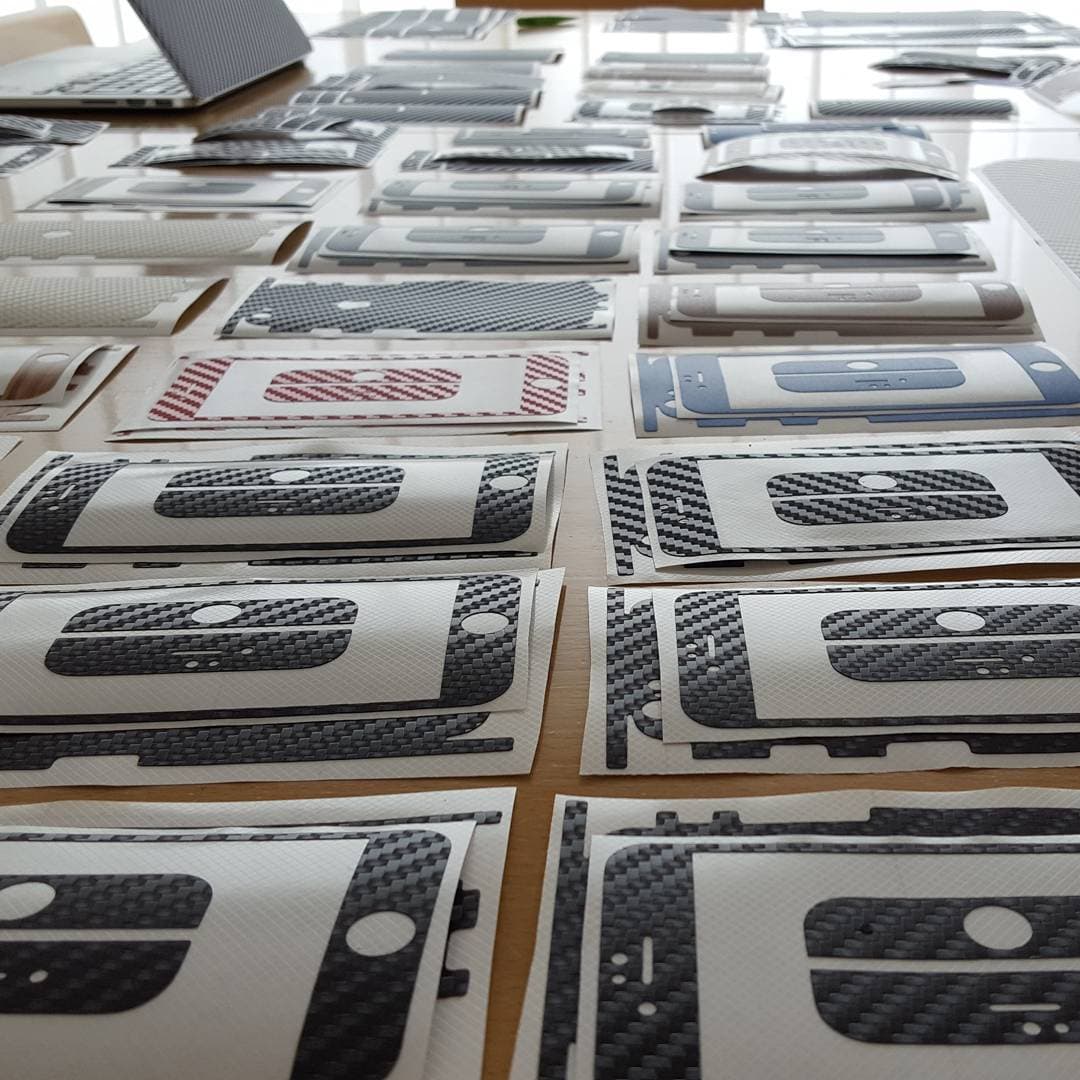 Rows of freshly cut carbon-fibre skins laid out on a table ready for the trade show